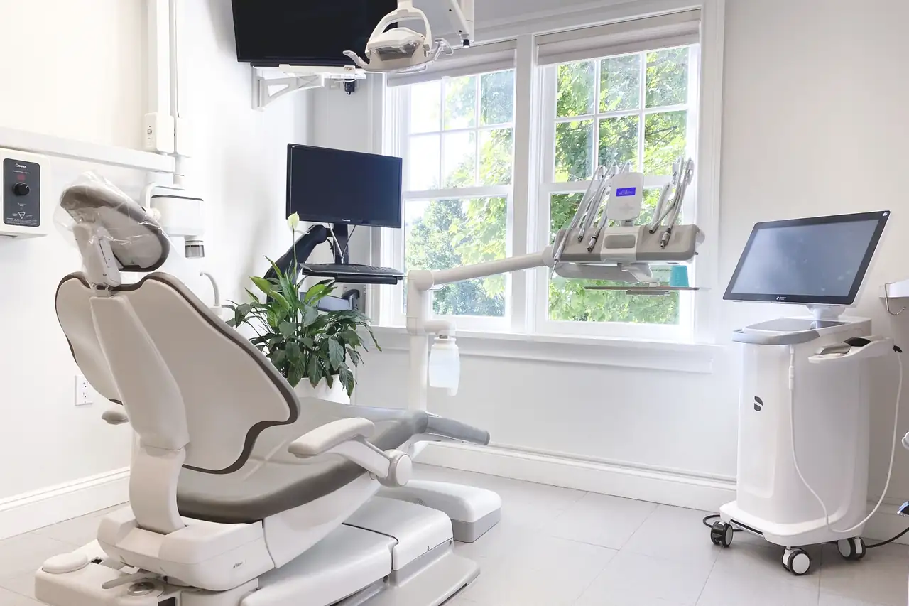 A bright treatment room at Lipari & Mangiameli Dentistry in Chappaqua, with the dental chair beside tall windows.