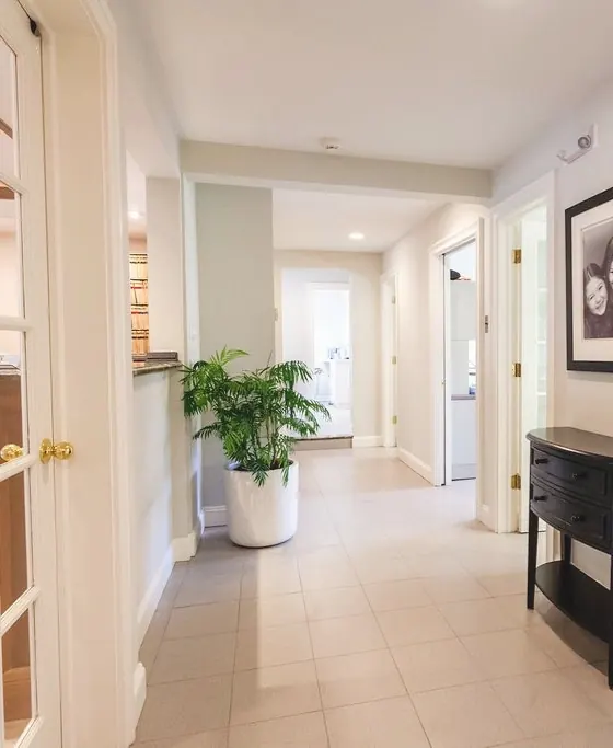 The bright hallway to the treatment rooms, with framed family photographs on the wall.